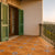 Balcony with 8*8 inch terrcacotta tiled floor and green shutters on a building.