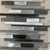 Mosaic XP-64 Tile 12x12 Inch – Linear mosaic with black, grey, and silver glass and aluminum in a mixed-texture, staggered strip design.

