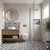 Modern bathroom with geometric tile pattern, wooden vanity, and round mirror.