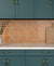 Lucido Base Honey Yellow glossy 8x8 inch tile on a kitchen backsplash with deep teal cabinets